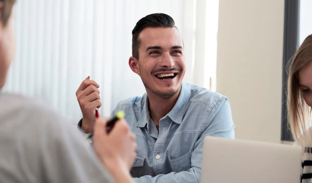 Young man laughing in meeting setting